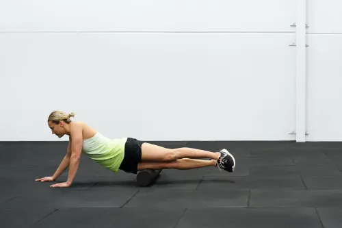 An athlete foam rolling her IT band to help with her Osgood-Schlatter