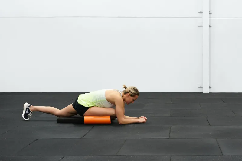 An athlete performing a glute stretch for her Osgood Schlatter knee pain