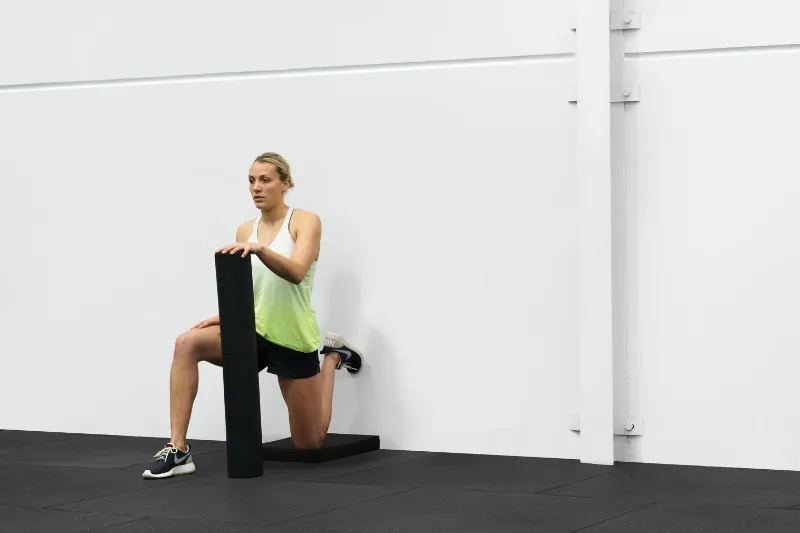An athlete performing a stretch for her Osgood Schlatter knee pain