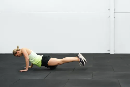 An athlete foam rolling her quads to help with her Osgood-Schlatter