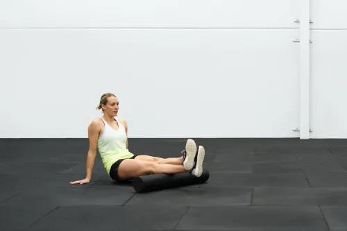 An athlete foam rolling her calves to help with her Osgood-Schlatter