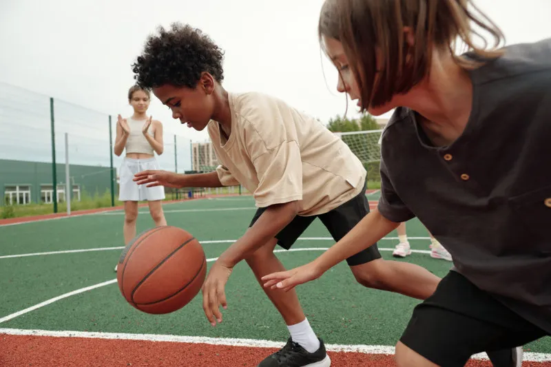 A junior athlete dribbling a basketball dynamically, pain-free — the Core Advantage training programs